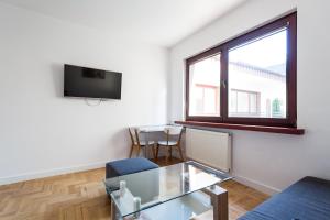 sala de estar con mesa de cristal y ventana en Apartamenty Robi en Kołobrzeg