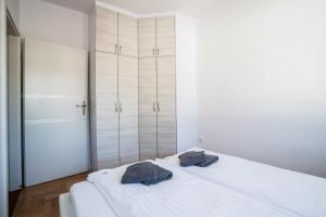 a bedroom with a white bed with two bags on it at Apartamenty Robi in Kołobrzeg
