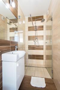 uma casa de banho com um lavatório e um chuveiro em Apartamenty Robi em Kolobrzeg
