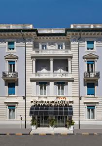 un gran edificio blanco con un cartel. en Palace Hotel en Viareggio