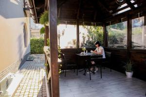 a woman sitting at a table on a patio at Hotel Marsen in Vinnytsya