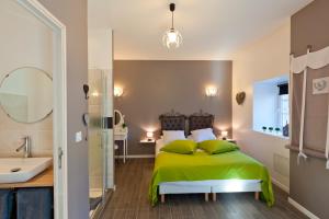 a bedroom with a green bed and a bathroom at Clos De La Gourmandière in Saint-Lothain +32 photos