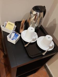 a black table with a tea pot and plates and spoons at Art & Jazz Hotel in Catania