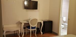 カターニアにあるアート ＆ ジャズ ホテルのテーブルと椅子、トイレが備わる小さな客室です。