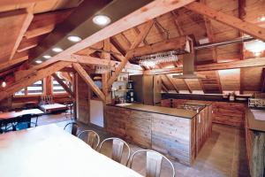 eine große Küche mit Holzdecken sowie Tischen und Stühlen in der Unterkunft chalet coup de coeur+véhicule 4*4 ; 9 places à dispo in La Clusaz