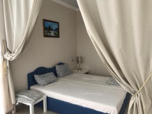 a bedroom with a bed with a curtain and a chair at U Valery in Novy Afon