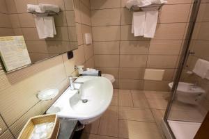 a bathroom with a sink and a mirror and a toilet at Art & Jazz Hotel in Catania
