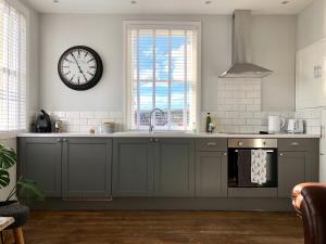 a kitchen with a large clock on the wall at The Drawing Office in Berwick-Upon-Tweed