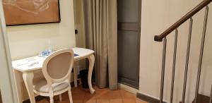 a small white table and chair in a room at Art & Jazz Hotel in Catania