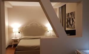 a bedroom with a bed and two lamps and a stairway at Art & Jazz Hotel in Catania