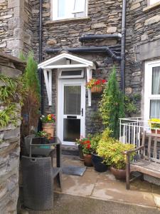 a house with a porch with a bench and some plants at 'Mysty' Studio style Winter deal on 3 nights or more Nov to Mar in Windermere