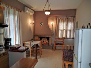 a kitchen and dining room with a table and a fireplace at Katerina Apartments in Agios Ioannis Pelio