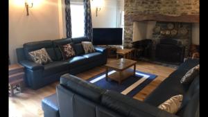 a living room with a couch and a fireplace at Aberystwyth, Pentre Farmhouse, in Capel Bangor