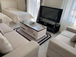 a living room with a tv and a couch and a table at Apartament Oresti in Korçë