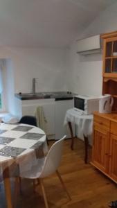 - une cuisine avec une table, une table et des chaises dans l'établissement Ferme Maya, à Saint-Genest-Lerpt