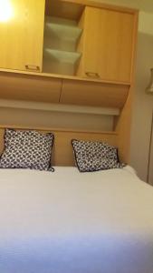 ein Bett mit zwei Kissen darüber in der Unterkunft Ferme Maya in Saint-Genest-Lerpt