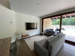a living room with a couch and a table at 2 Apartamentos en villa con piscina privada en Asturias El Marquesau in Noriega