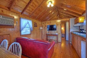 a living room with a red couch in a cabin at Riverbend Lodging in Bryson City