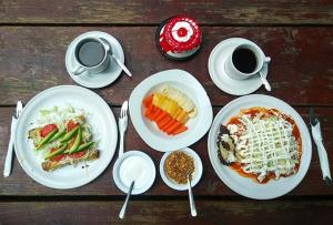 a wooden table with plates of food and cups of coffee at Cabañas El Rincón de Pancho in Altotonga