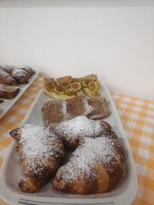 un vassoio di prodotti da forno con zucchero in polvere su un tavolo di Casa per Ferie Ulivo d'Assisi ad Assisi