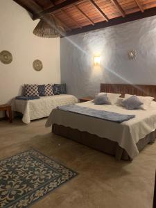 a bedroom with two beds and a rug in it at Vila Sol Chalés in Pôrto de Pedras