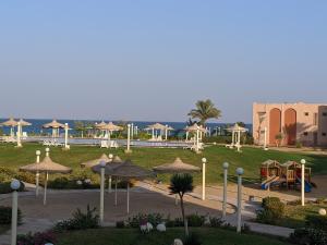 艾因蘇赫納的住宿－Ain El Sokhna ground floor, with Pool & Sea view，一个带遮阳伞和游乐场的公园