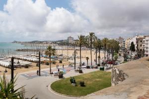 a view of a beach with palm trees and the ocean at Sitgesnextdoor in Sitges