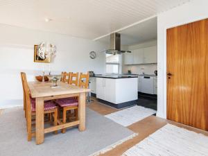 Il comprend une cuisine et une salle à manger avec une table et des chaises en bois. dans l'établissement 8 person holiday home in Skagen, à Skagen