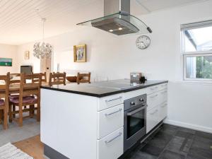 eine Küche mit einem Herd Top-Backofen neben einem Esszimmer in der Unterkunft 8 person holiday home in Skagen in Skagen