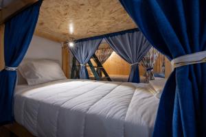 a bedroom with a bed with blue curtains at Hostel O Torneiro in Pernes