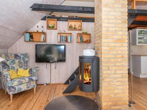 a living room with a fireplace and a tv at Holiday home Fanø VI in Fanø