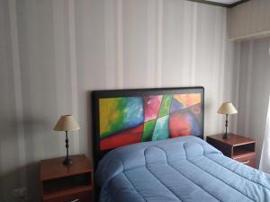 sypialnia z łóżkiem i dużym telewizorem w obiekcie Departamento Maru w mieście Tandil