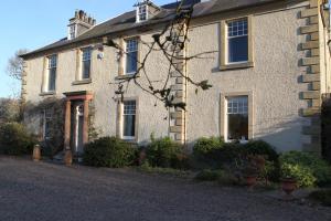 a white brick house with a driveway in front of it at Kirklands House in Melrose