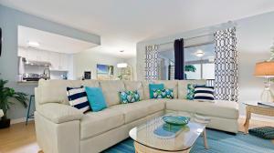 sala de estar con sofá blanco y almohadas azules en Your Hidden Private Gem "La Playa Azul", en San Petersburgo