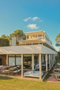 un edificio con mesas y sillas delante de él en Posada Azul Marino, en José Ignacio