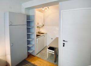 a kitchen with a white refrigerator and a table at Komiza Provita Guesthouse in Komiža