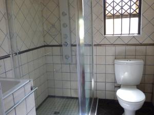 a bathroom with a toilet and a shower and a sink at Royal Guest House in East London