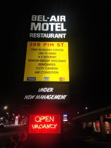 a sign for a motel restaurant with a neon sign at Bel-Air Motel in Sault Ste. Marie