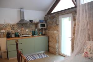a kitchen with a counter and a door in a room at Bosque dos Amieiros in Marco de Canavezes