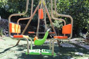 an empty playground with orange and green swings at Bosque dos Amieiros in Marco de Canavezes