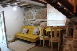 a living room with a yellow couch and a table at Bosque dos Amieiros in Marco de Canaveses