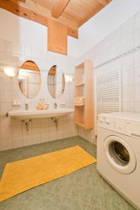 baño con lavadora y 2 espejos en Vorderstockerhof, en Sankt Johann in Tirol