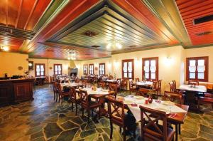 a restaurant with tables and chairs in a room at Papigiotis Hotel in Tsepelovo