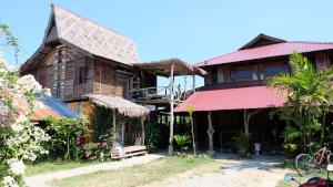 uma casa velha com um telhado vermelho em The Kasbah Langkawi em Pantai Cenang