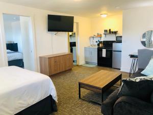a hotel room with a bed and a living room at Blue Sage Inn & Suites in Blanding
