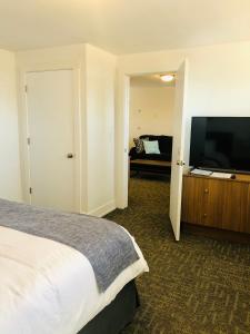 una camera con letto e TV a schermo piatto di Blue Sage Inn & Suites a Blanding