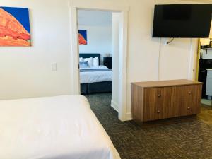 Habitación de hotel con cama y TV en Blue Sage Inn & Suites en Blanding