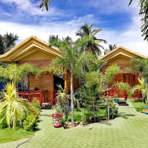 uma casa com palmeiras em frente em Sea View Resort em Kallady