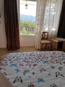 uma cama com borboletas num quarto com uma janela em Casa Tonyza em Cisnădie