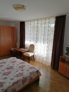 um quarto com uma cama, uma mesa e uma televisão em Casa Tonyza em Cisnădie